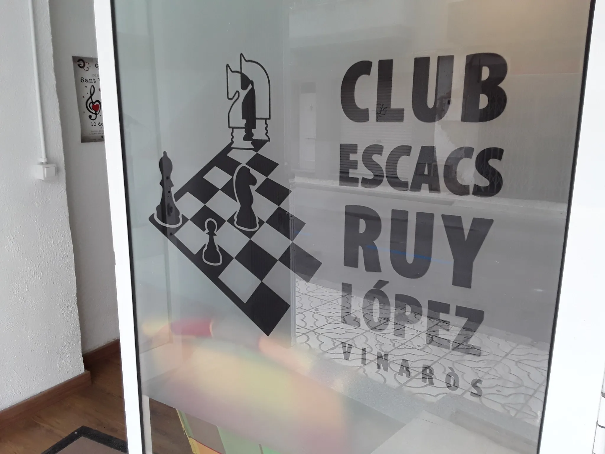 Detalle de la puerta con el nombre y el emblema del Club Escacs Ruy López de Vinaròs